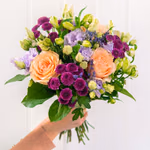 Small, round bouquet of apricot roses, purple santini, lilac lisianthus and cream alstroemeria