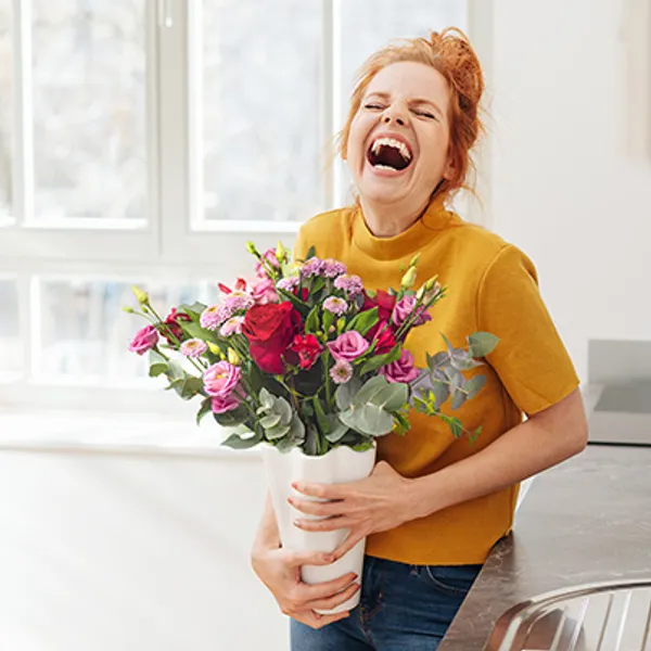 Woman smiling and holding flowers