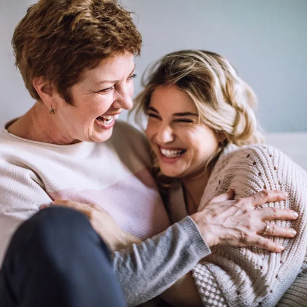 Two women laughing and hugging 
