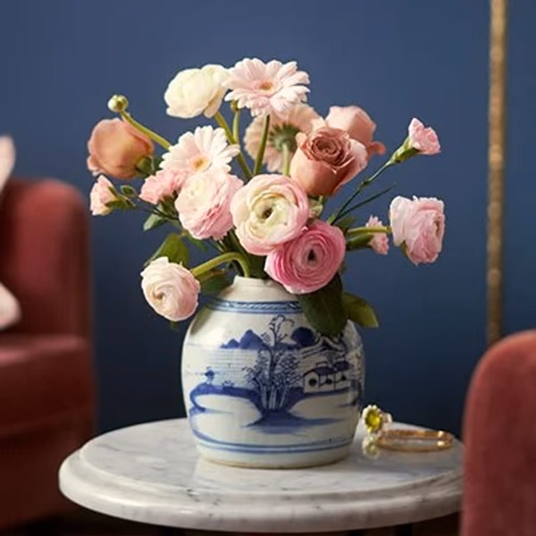 a bouquet of pink flowers in a white and blue vase