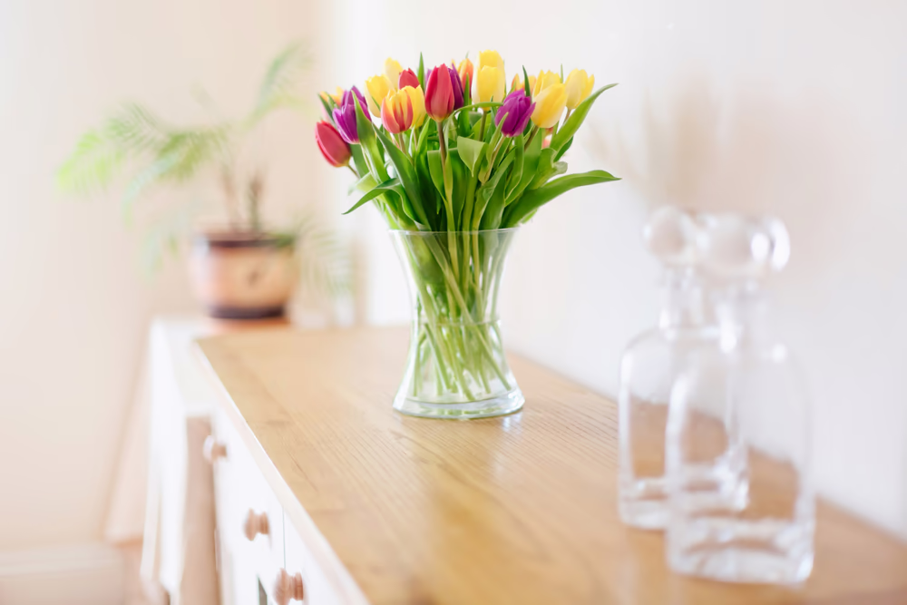 Tulips in a vase on a sideboard