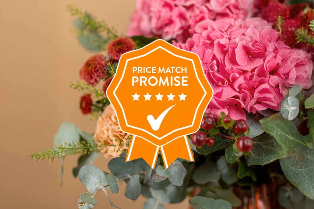 A flower bouquet of pink hydrangeas, eucalyptus, and various flowers with an orange price match promise badge overlaid.