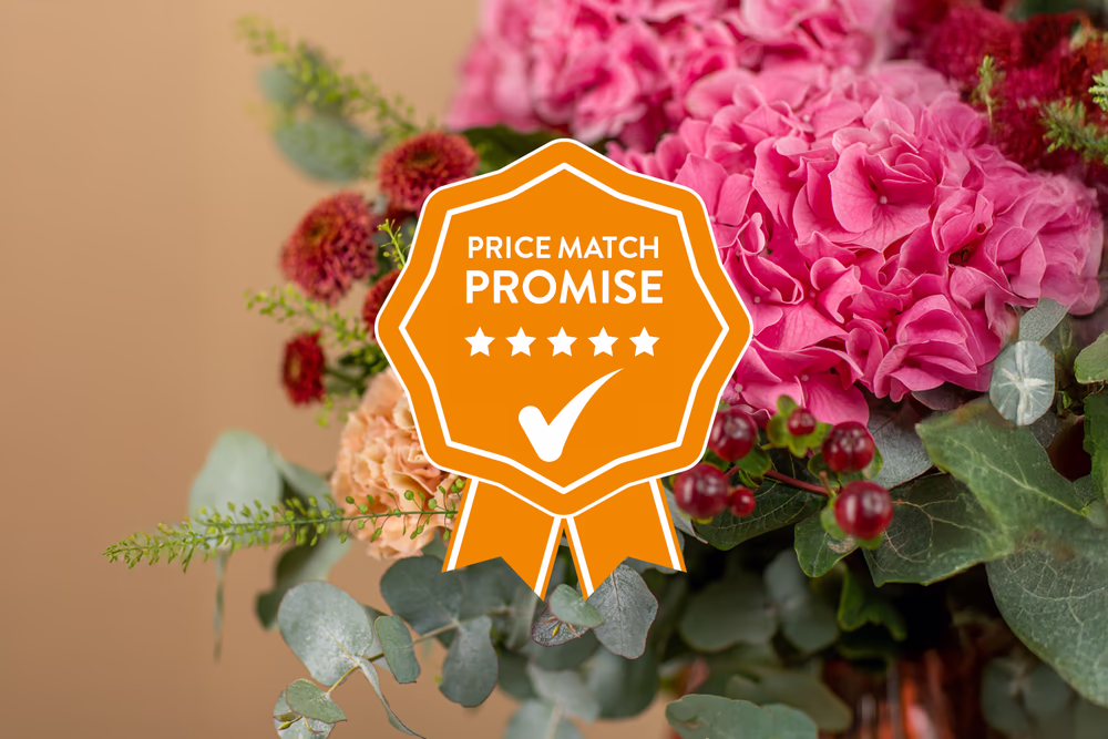 A flower bouquet of pink hydrangeas, eucalyptus, and various flowers with an orange price match promise badge overlaid.