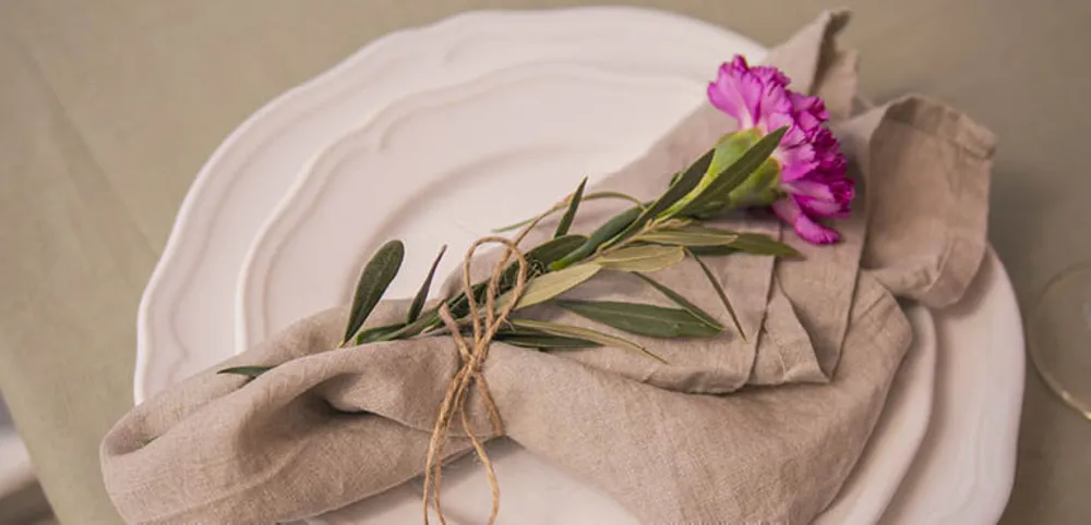 En enkelt blomst på toppen av et sett med tallerkener